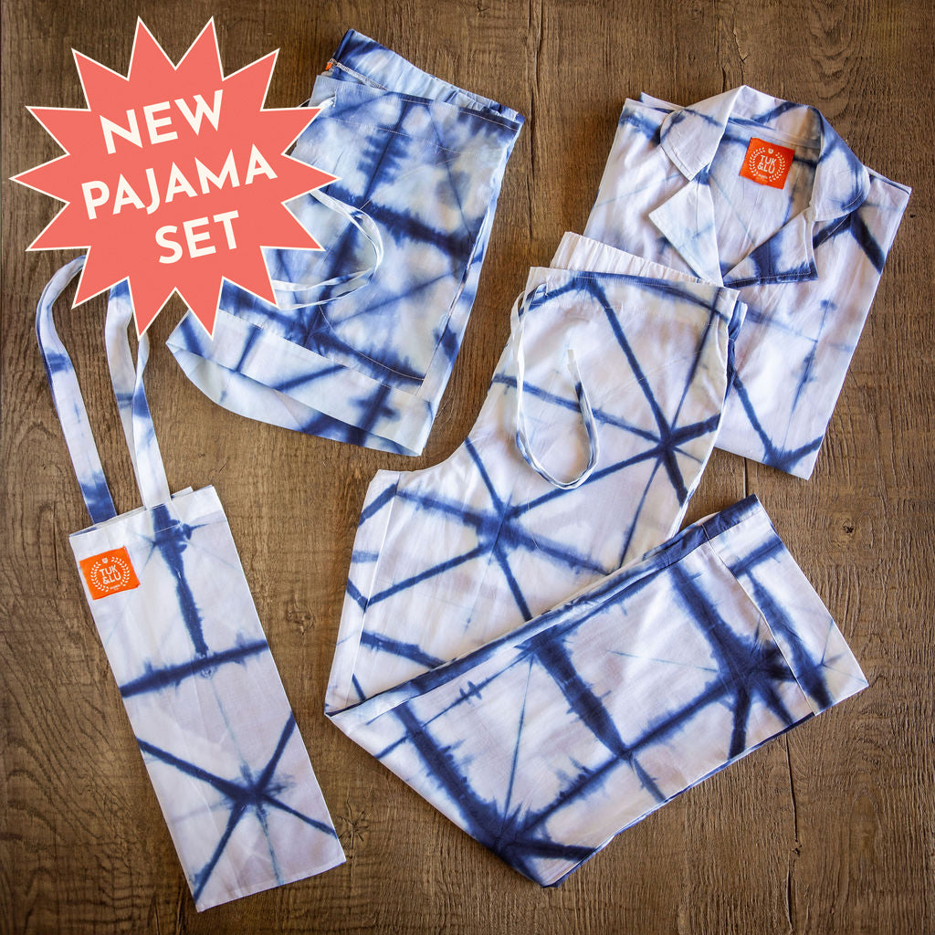 Four piece blue tie-dyed cotton pajama set featuring button down top, shorts, pants and matching tote.