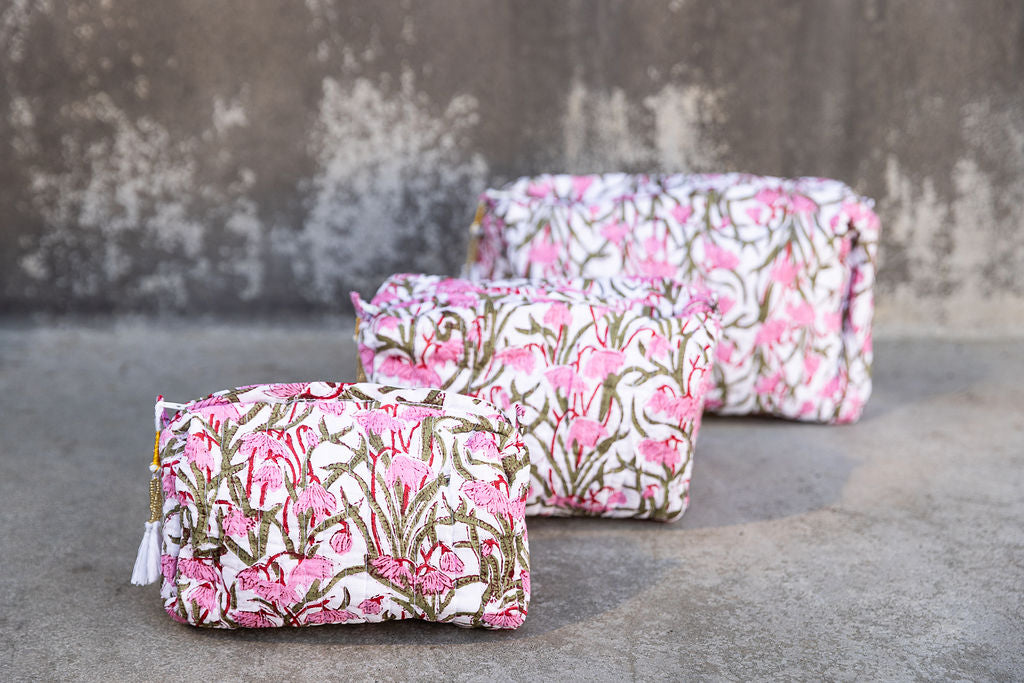 Set of three pink and green patterned cotton cosmetic bags. Smaller bags fit into the largest for easy storage.