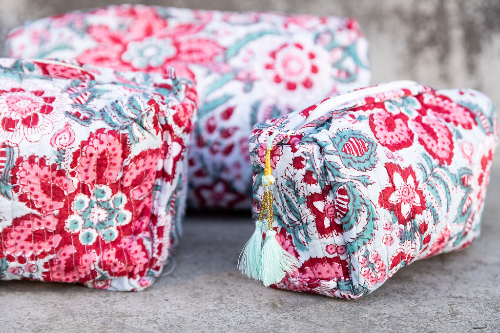Set of three multi-colored patterned cotton cosmetic bags. Smaller bags fit into the largest for easy storage. Detail