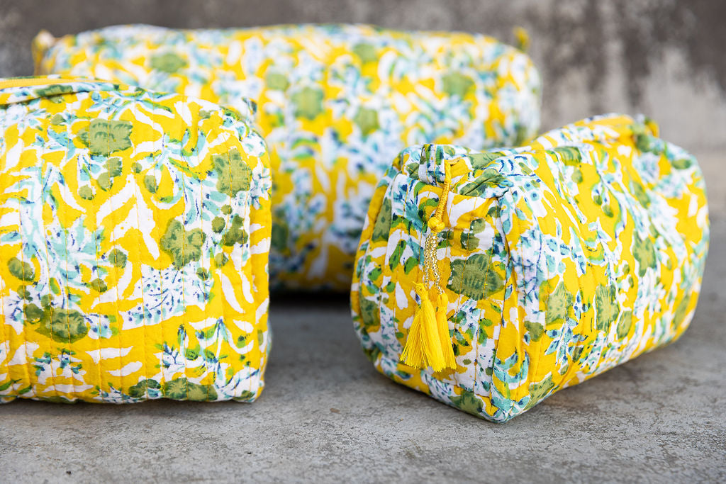 Detail of a set of three multi-colored patterned cotton cosmetic bags. Smaller bags fit into the largest for easy storage.