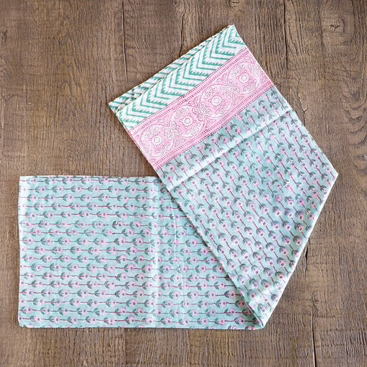 Image of model displaying Tuk and Lu's Sarong. Can be use as a shawl or cover up. Delicate pink flowers on a light green background.