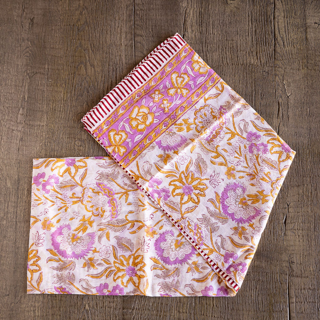Unique hand-blocked printed, 100% cotton sarongs. Can also be used as a cover up. Pink and yellow pattern on white.
