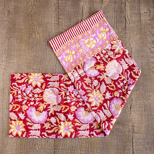 Image of model displaying Tuk and Lu's Sarong. Can be use as a shawl or cover up. Beautiful yellow and pink floral with red background.