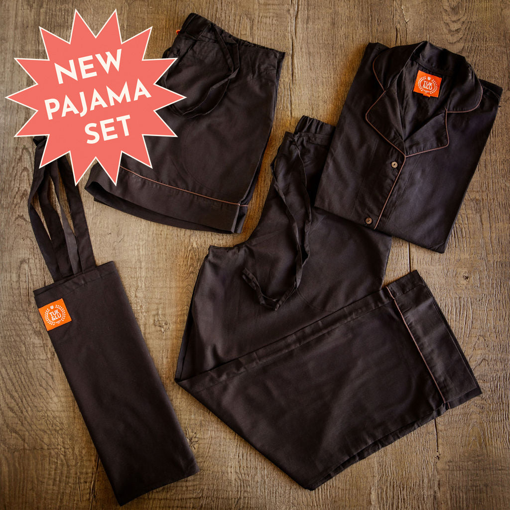 Four piece black cotton pajama set featuring button down top, shorts, pants and matching tote.