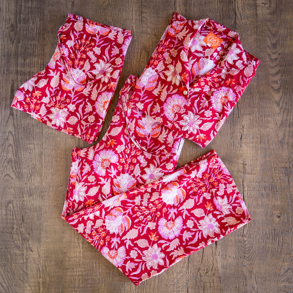Four piece red cotton pajama set featuring button down top, shorts, pants and matching tote.
