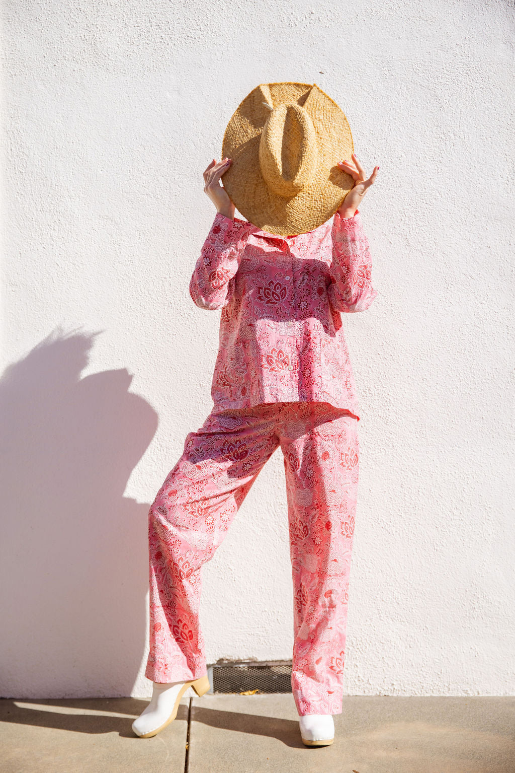 Model wearing Tuk and Lu's pink patterned cotton PJ set with the top and pants. Comes with a tote for easy travel.