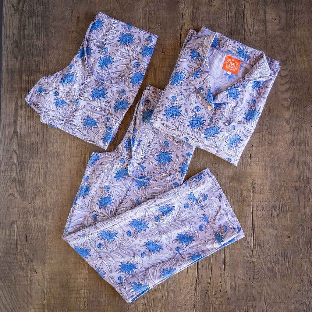 Four piece patterned cotton pjs featuring button down top, shorts, pants and matching tote. Blue and Lavender