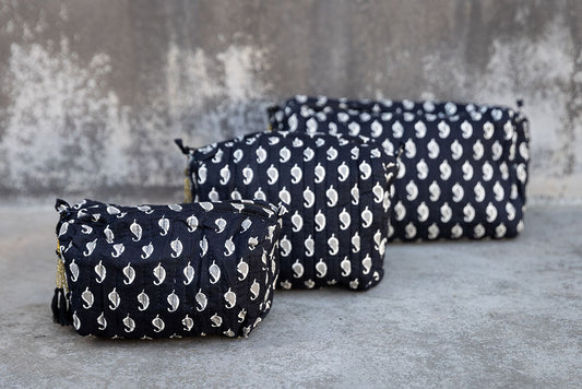 Set of three multi-colored patterned cotton cosmetic bags. Smaller bags fit into the largest for easy storage. Black/