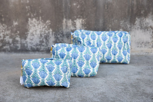 Set of three multi-colored patterned cotton cosmetic bags. Smaller bags fit into the largest for easy storage. Blue floral on white.