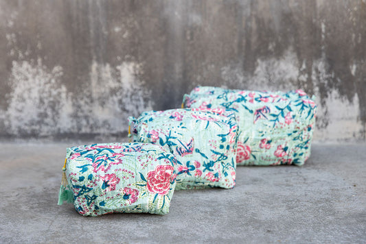 Set of three multi-colored patterned cotton cosmetic bags. Smaller bags fit into the largest for easy storage. Floral pattern on celadon green.