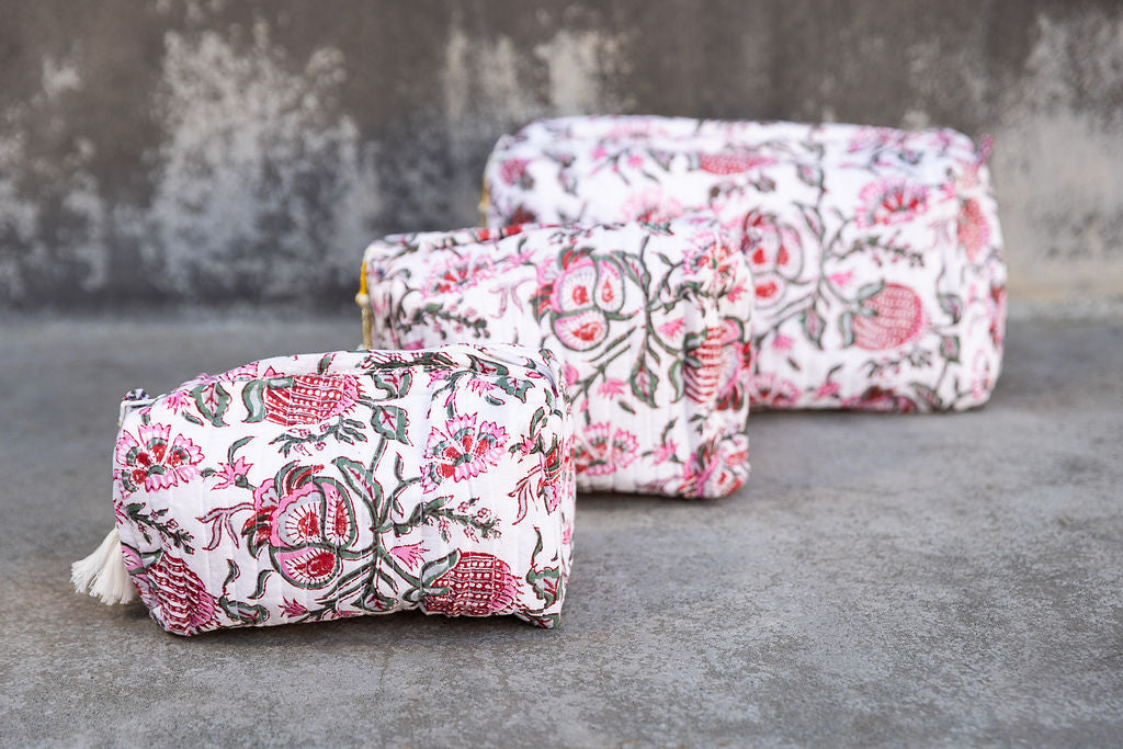 Set of three multi-colored patterned cotton cosmetic bags. Smaller bags fit into the largest for easy storage.