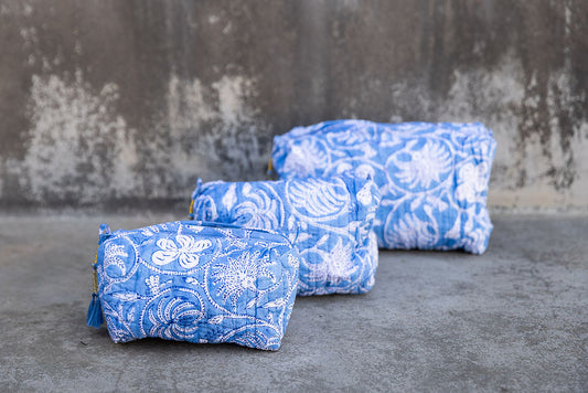 Set of three multi-colored patterned cotton cosmetic bags. Smaller bags fit into the largest for easy storage. Floral pattern on sky blue.
