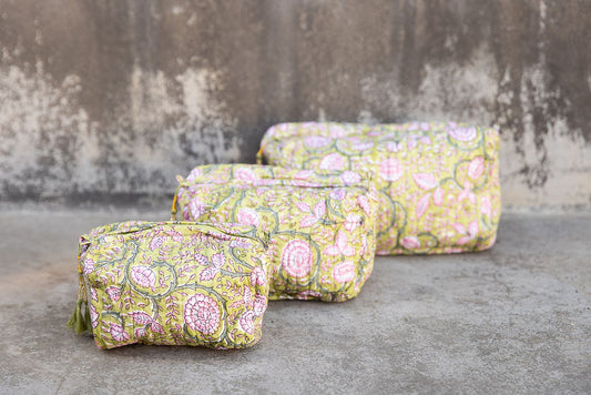 Set of three multi-colored patterned cotton cosmetic bags. Smaller bags fit into the largest for easy storage. Floral design on yellow.
