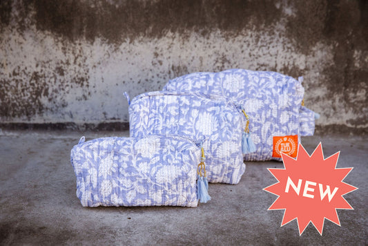 Set of three floral patterned cotton cosmetic bags. Smaller bags fit into the largest for easy storage. white floral pattern on lavender.