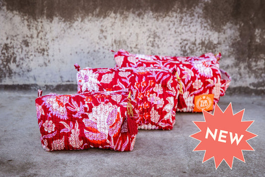 Set of three floral patterned cotton cosmetic bags. Smaller bags fit into the largest for easy storage. floral pattern on red.