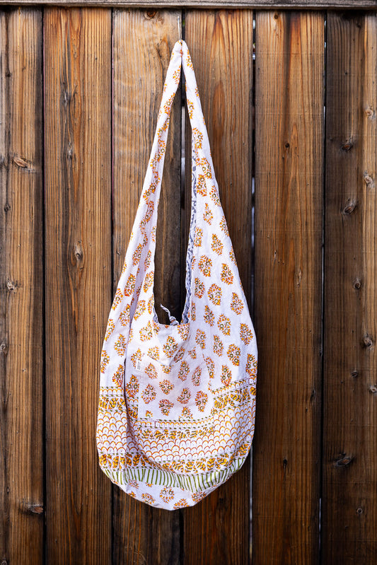 Unique, reversible slouch bag collection. Available in different patterns and colors. Yellows and pink design on white.