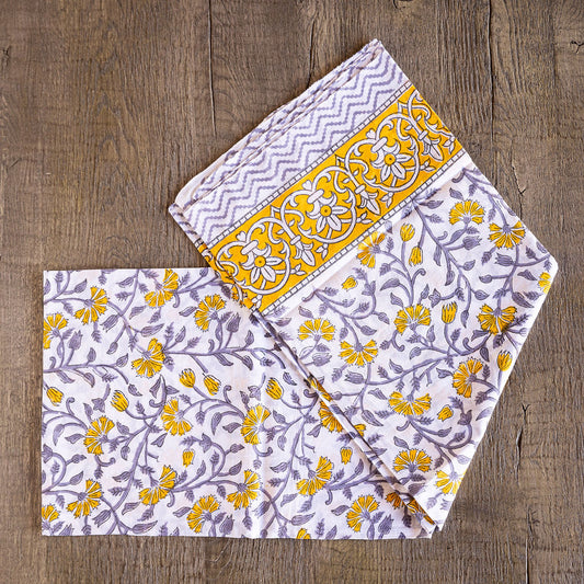 Image of model displaying Tuk and Lu's Sarong. Can be use as a shawl or cover up. Purple and yellow floral design on white.